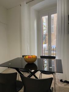 a glass table with a bowl of fruit on it at Appartement en plein Centre in Calvi +1 photo