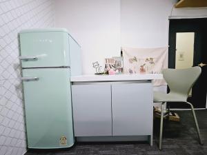 a refrigerator in a room with a table and a chair at K Highstel Uijeongbu 35 in Uijeongbu