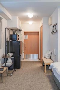 Zimmer mit einem Kühlschrank und einem Zimmer mit einem Bett in der Unterkunft b&通天閣店 in Osaka