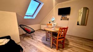 a small room with a table and chairs and a television at Zielona Przestrzeń in Polańczyk