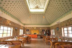 une salle à manger avec des tables et des chaises en bois dans l'établissement Ananda Resort, à Pushkar