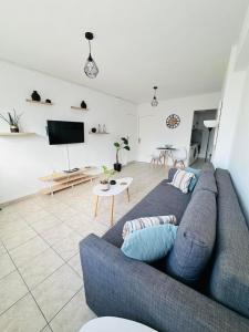 ein Wohnzimmer mit einem blauen Sofa und einem TV in der Unterkunft Central Apartment Next To The Beachfront in Iraklio