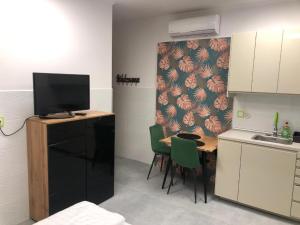 a kitchen with a small table with a tv on it at Levél 1 3 - közös fürdőszoba shared bathroom in Szeged