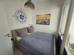 1 dormitorio con 1 cama y reloj en la pared en FeWo Prora- Stubbenkammer, en Binz