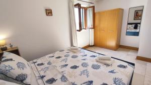 a bedroom with a bed with a blue and white blanket at Apartman Linda in Milna