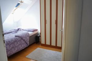 a small bedroom with a bed and a window at Experience Novi Sad Residence in Novi Sad