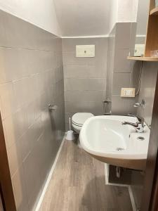 ein Badezimmer mit einem weißen Waschbecken und einem WC in der Unterkunft Casa Nora in Manerba del Garda
