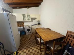 eine Küche mit einem Holztisch und einem Kühlschrank in der Unterkunft Casa Nora in Manerba del Garda