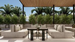um pátio com cadeiras, mesas e palmeiras em Hotel Namah Courtyard em Khāpri