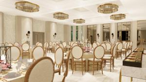um salão de banquetes com mesas e cadeiras numa sala em Hotel Namah Courtyard em Khāpri