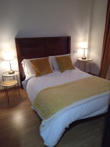 a bedroom with a large bed with two lamps at Rincón de María José in Monachil