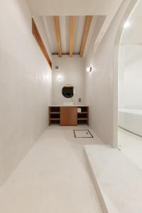a room with white walls and a tv on a wall at Amami 与庵 in Amami