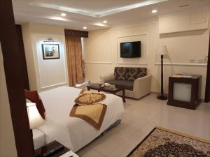 Falettis Express DHA في لاهور: غرفه فندقيه بسرير واريكه