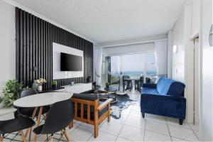 uma sala de estar com um sofá azul e uma mesa em Seagull 311 em Margate