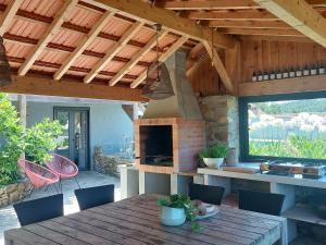 un patio con mesa de madera y chimenea en Casa Bem Estar, en Mortágua