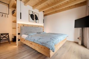 a bedroom with a wooden bed and a tv at Refugio in Sittersdorf
