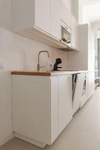a kitchen with white cabinets and a sink at Apartamento Barcelona centro in Barcelona