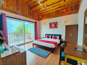 a bedroom with a bed and a large window at Satopanth The Auli Resort By Royal Collection Hotels in Joshīmath