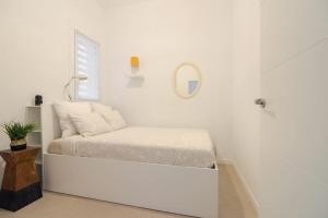 a white room with a bed and a mirror at Apartamento Barcelona centro in Barcelona