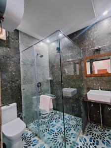 a bathroom with a shower and a toilet and a sink at Satopanth The Auli Resort By Royal Collection Hotels in Joshīmath