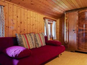 a red couch in a room with wooden walls at Peaceful Apartment in Rauris near Ski Area Zell am See in Rauris