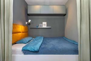 een kleine slaapkamer met een bed met blauwe lakens bij City Apartment mit Sonnenbalkon in Wuppertal