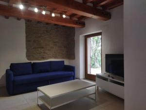 un salon avec un canapé bleu et une télévision dans l'établissement Casa vacanza nel verde, à San Clemente in Valle
