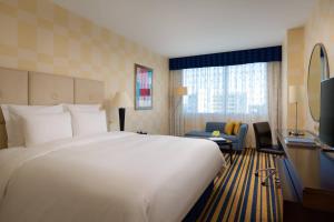 a hotel room with a large bed and a tv at Renaissance Aktau Hotel in Aktau