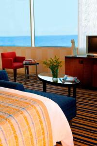 a hotel room with a bed and a table and a television at Renaissance Aktau Hotel in Aktau