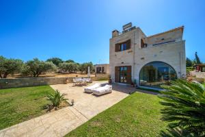 a large stone building with a patio in the yard at FOS residence - ΦΩΣ ,luxury house in Chania