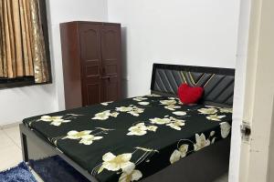 Una cama con una manta negra con flores. en Saral Sky Near Agora Mall, en Ahmedabad