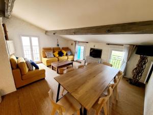Una sala de estar con una mesa y sillas de madera. en Appartement T6. Emplacement et vue mer d'exception, en Collioure