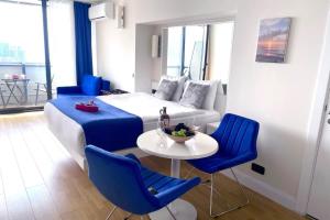 Habitación de hotel con cama, mesa y sillas en Orbi city blok c vip wiev, en Batumi