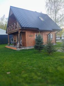 a log cabin with a black roof on a yard at Eko Przystanek in Kępie Żaleszańskie