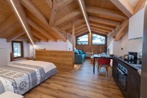 a bedroom with a bed and a kitchen in a room at La Racine in La Thuile