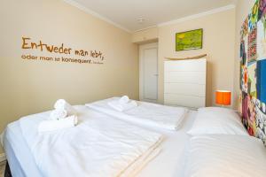 duas camas num quarto com lençóis brancos em Haus Dünenburg Dünenburg App 23 em Westerland