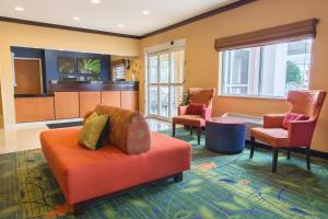 sala de estar con sofá naranja y sillas en Fairfield Inn & Suites Fargo, en Fargo