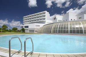 a building with a swimming pool in front of a building at Satsuma Resort Hotel in Satsuma