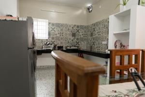 a kitchen with a refrigerator and a counter top at Maya Homez - Coimbatore in Coimbatore +17 photos