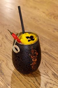 a black cup with a flower on a table at Gite de Amiens Poulainville in Poulainville