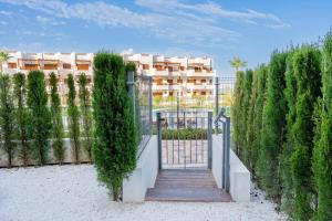 eine Treppe, die zu einem Tor mit einem Gebäude im Hintergrund führt in der Unterkunft Casa Mira aparamento con jardín y piscina comuni in San Juan de los Terreros