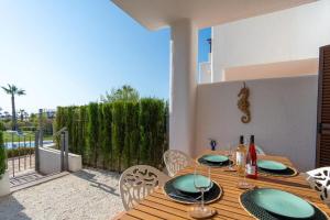 einen Holztisch und Stühle auf einer Terrasse in der Unterkunft Casa Mira aparamento con jardín y piscina comuni in San Juan de los Terreros