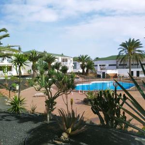 vista su un resort con piscina e palme di oasismarverdemar a Corralejo