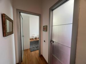 einen leeren Flur mit Tür und Spiegel in der Unterkunft Il capitello in La Spezia