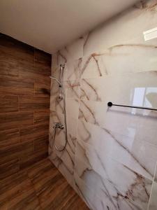 a bathroom with a marble wall with a shower at Апартамент БОХО Приморско in Primorsko