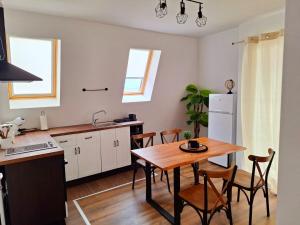 a kitchen and dining room with a table and chairs at Апартамент БОХО Приморско in Primorsko