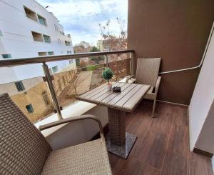 a balcony with a wooden table and two chairs at Апартамент БОХО Приморско in Primorsko