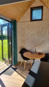 einen Tisch und Stühle in einem Zimmer mit Fenster in der Unterkunft Tiny house Giethoorn in Giethoorn