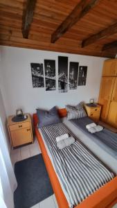 duas camas num quarto com fotografias na parede em U Bloku em Donji Miholjac