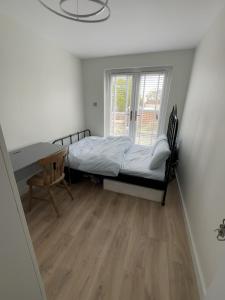 a bedroom with a bed and a desk and a window at Brand new suit room 10 min to walk central line! in Woodford